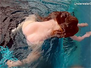 red-haired Simonna showing her assets underwater
